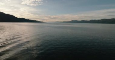 Gün batımında Toba Gölü 'nün su yüzeyinde uçuş. Sumatra, Endonezya.