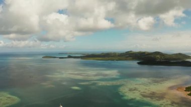 Mavi gökyüzünün altında turkuaz mercan resif suyuna sahip tropik adalar. Bulutlar, hava aracı. Bucas grande, Filipinler. Yaz ve seyahat tatil konsepti.