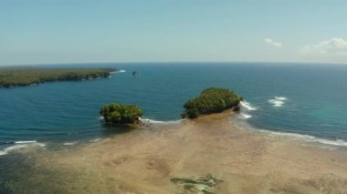 Okyanustaki tropik adalar, kıyıya vuran dalgalar, üst manzara. Siargao, Filipinler. Yaz ve seyahat tatil konsepti.