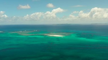 Mercan resifli mavi deniz, gökyüzünün altındaki bulutlu adalar, üst manzara. Yaz ve seyahat tatili konsepti. Siargao, Filipinler.