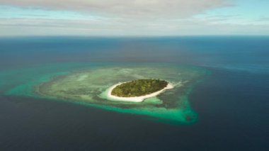 Mercan resifleriyle çevrili güzel kumlu plajlı bir mercan adasında küçük bir tropikal ada. Tropik ada ve mercan resifi. Yaz ve seyahat tatili konsepti, Camiguin, Filipinler, Mindanao