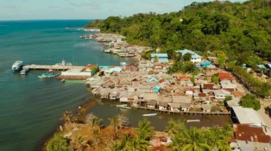 Balıkçı köyünde suyun içinde duran ev halkı. Filipinler, Palawan 'daki Balabac Adası' ndaki şehir limanı. Balıkçı köyünde denizin üzerinde duran eski ahşap bir ev.