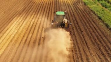 Bir patates tarlası üst görünümünde disk tepeli ile Traktör Hilling Patates. Tarım arazilerinde tohum yatağı yetiştiriciliği ile arazi hazırlayan traktör çiftçi
