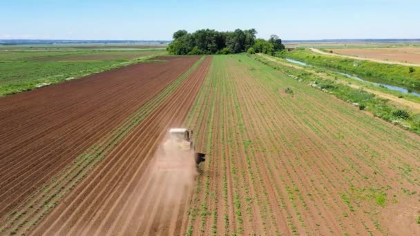 トラクター丘ジャガイモ畑の空中ビューでディスクヒラーとジャガイモ 土地や肥料の準備をする農民 — ストック動画