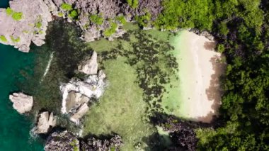 Turistlerin ve mavi denizin bulunduğu tropikal ada, hava manzaralı. Matukad Adası, Caramoan Adaları, Filipinler. Küçük bir plajı olan Rocky Adası. Yaz ve seyahat tatil konsepti.