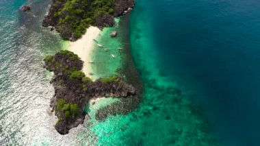 Turistlerin ve mavi denizin bulunduğu tropikal ada, hava manzaralı. Lahos Adası, Caramoan Adaları, Filipinler. Yaz ve seyahat tatil konsepti.