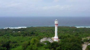 Aerial view: Cape Bolinao Lighthouse. Beautiful landscape, lighthouse on the island of Luzon. Summer and travel vacation concept. Ocean coast with rainforest. Luzon Island, Philippines.