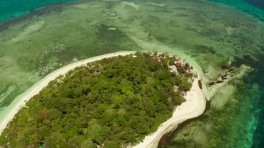 Mavi denizde, mercan resifli tropik bir ada. Kumsallı küçük bir ada. Yaz ve seyahat tatil konsepti, Mantigue Adası, Filipinler, Mindanao