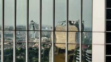 Jakarta şehrinin yansıması bir gökdelenin ayna camlarında. Endonezya.