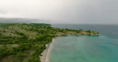 Tropikal kumlu deniz burnu ve fırtınalı havada mavi okyanus. Pasir Putih plajı. Aceh, Sumatra, Endonezya.