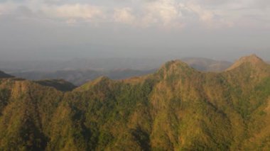 Mavi gökyüzüne ve bulutlara karşı dağlarda gün batımı. Filipinler.