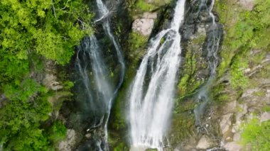 Aerial view of Waterfall among tropical jungle with green plants. Slow motion. Balea Falls in the jungle. Negros, Philippines.