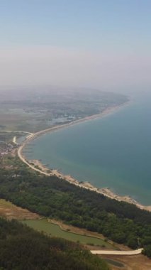 Balıkçı köyleri ve balık çiftliklerinin olduğu kıyı şeridi yukarıdan görünüyor. Luzon, Filipinler. Dikey video.