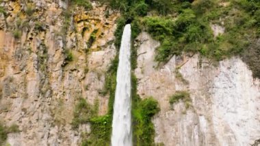 Yağmur ormanları ve bitki örtüsü arasında çok güzel bir şelalenin insansız hava aracı. Sipiso Piso ağır çekimde düşüyor. Sumatra, Endonezya.