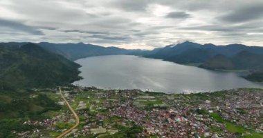 Şehir manzarasını dağların tepesinden tarlaların ve Tawar Gölü 'nün ortasından alın. Sumatra, Endonezya.