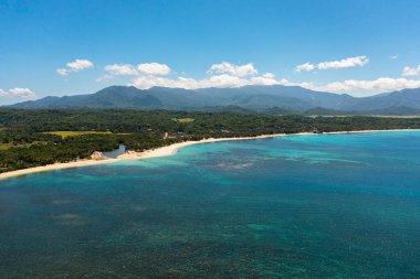 Tropikal kumlu ve mavi okyanuslu deniz burnu. Pagudpud, Ilocos Norte, Filipinler.