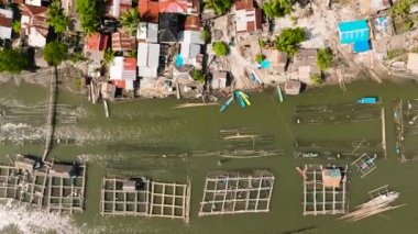 Nehirde balık çiftliği olan köyün havadan görünüşü. Hinigaran Nehri. Zenciler, Filipinler