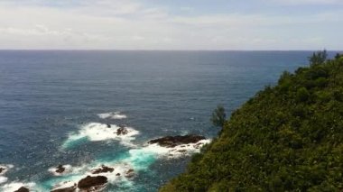 Adanın kıyıları ve mavi gökyüzüne karşı deniz. Santa Ana, Luzon, Filipinler.