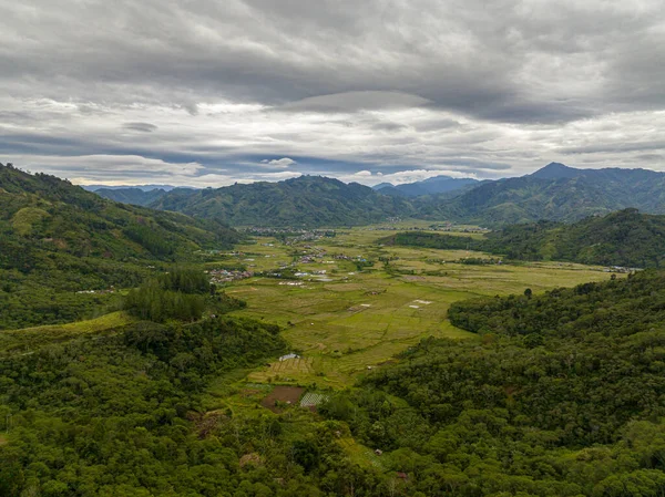 在农场和山区之间的山谷中的城镇的空中无人驾驶飞机 高刚苏门答腊印度尼西亚 — 图库照片