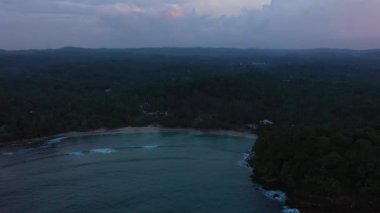 Körfezin ve okyanusun üzerindeki günbatımının havadan görünüşü. Hiriketiya, Sri Lanka.