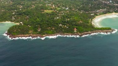 Palmiye ağaçlarının arasında Hiriketiya plajı olan körfez manzarası. Sri Lanka 'da sörf yeri.