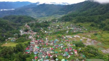 Kasaba dağlarla çevrili, üst bir manzara. Filipinler 'in Luzon Adası' ndaki Sagada şehrinde. Bir dağ kasabasının evleri ve sokakları. Cordillera dağlarındaki köy.