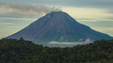 Sinabung Dağı etkin stratovolcano bulutlarla kaplı. Sumatra, Endonezya.