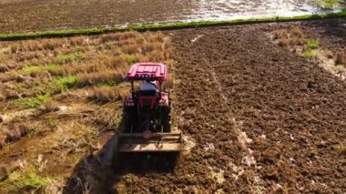 Traktör pirinç ekmek için toprağı sürer. Filipinler 'de tarım işi. Traktör Asya 'da tarlalarda çalışıyor..