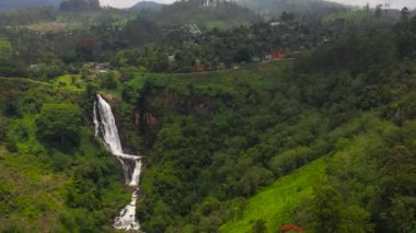 Köyleri ve çay tarlaları olan tepeler arasındaki şelale manzarası. Devon Şelaleleri, Sri Lanka.