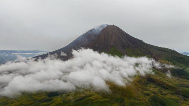 Aktif volkan Sinabung bulutlar ve dumanla. Sumatra, Endonezya.