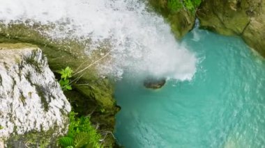 Yağmur ormanları ve bitki örtüsü arasında yavaş çekimde şelalenin en üst görüntüsü. Cebu, Filipinler.