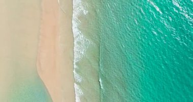 Temiz su ve deniz sörfü ile güzel kumlu sahil manzarası. Borneo, Malezya.