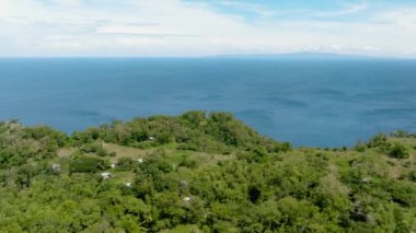 Adadaki tropikal bitki örtüsünün arasındaki evler. Apo Adası. Zenciler, Filipinler.