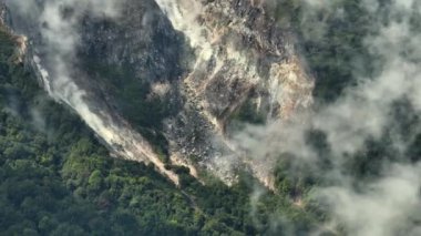 Yağmur ormanları arasında duman ve gazlarla Sibayak volkanının havadan görünüşü. Sumatra, Endonezya.