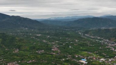 Çiftlik arazileri ve dağların arasındaki bir vadide şehrin havadan görünüşü. Takengon, Sumatra. Endonezya.