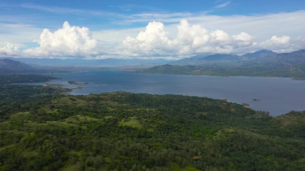 緑の丘や熱帯雨林に覆われた山々の間の青い湖の上の雲 空中ビュー パンタバンガン湖 フィリピン ルソン島 — ストック動画