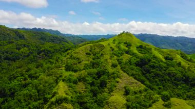 Yaz tropik manzarası. Yeşil tepeler ve dağlarla tropikal bitki örtüsü ve bulutlu mavi gökyüzü. Bohol, Filipinler.