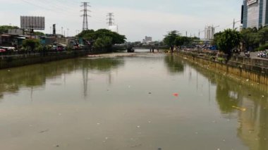 Kirlenmiş Ciliwung nehri, Endonezya 'nın Jakarta kenar mahallelerinde çöplerle doludur..
