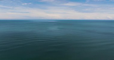 Açık mavi deniz, gökyüzüne ve bulutlara karşı dalgalar. Tropik bölgelerde deniz manzarası. Borneo, Malezya.