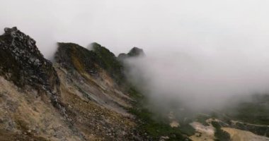 Aktif volkan krateri Sibayak 'ın bulutlar ve sis içindeki hava görüntüsü. Sumatra, Endonezya.