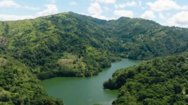 A beautiful lake among the mountains with tropical vegetation. Lake Balanan. Negros, Philippines