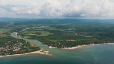 The river flows into the sea and the beach. Tropical landscape. Sipalay, Negros, Philippines.