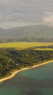 Gün batımında sahili olan kıyı şeridinin hava aracı, dağların arka planına karşı. Pagudpud, Ilocos Norte, Filipinler.