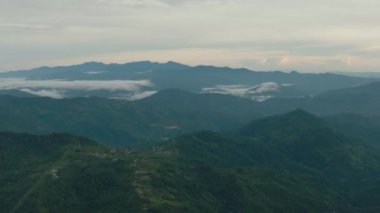 Dağların ve tepelerin havadan görünüşü bulutlarla kaplıdır. Dağ manzarası. Borneo, Sabah, Malezya.