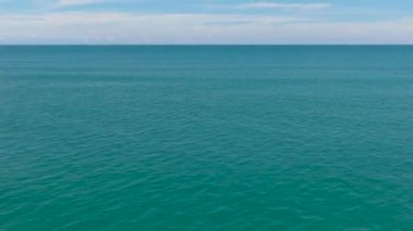 Gökyüzüne ve bulutlara karşı dalgalı açık mavi deniz manzarası. Tropik bölgelerde deniz manzarası. Borneo, Malezya.