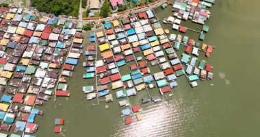 Borneo adasındaki balıkçı köyünde yukarıdan deniz manzaralı cambaz kulübelerinde evler var. Sandakan, Malezya.