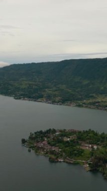 Toba Gölü 'ndeki Tuk Tuk Tuk ve Samosir Adası sahilleri. Sumatra, Endonezya. Tropikal manzara.