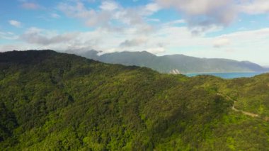 Ormanı ve mavi denizi olan dağlar. Dağ yamaçları yağmur ormanlarıyla kaplı. Filipinler.