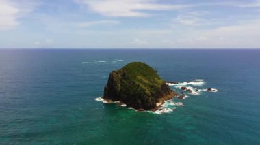 Aerial drone of rocky island in the ocean and sea surf. Santa Ana, Cagayan. Philippines.