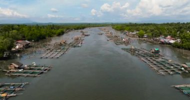 Nehirde kafesleri ve ağları olan balık çiftliğinin havadan görünüşü. Balıkçı köyü Hinigaran Nehri. Zenciler, Filipinler